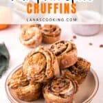 A plate stacked with pumpkin spice cruffins topped with icing, with more cruffins in the background.