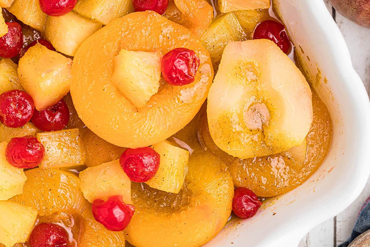 Finished baked curried fruit in a white baking dish.