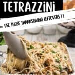 Tongs serving creamy turkey tetrazzini casserole from a white baking dish, topped with parsley.