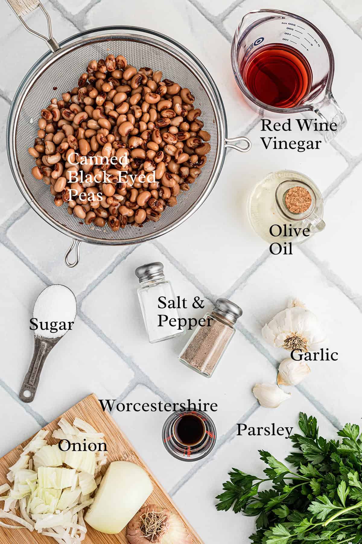 Ingredients for a recipe, including black-eyed peas, vinegar, oil, garlic, onion, parsley, and seasonings.