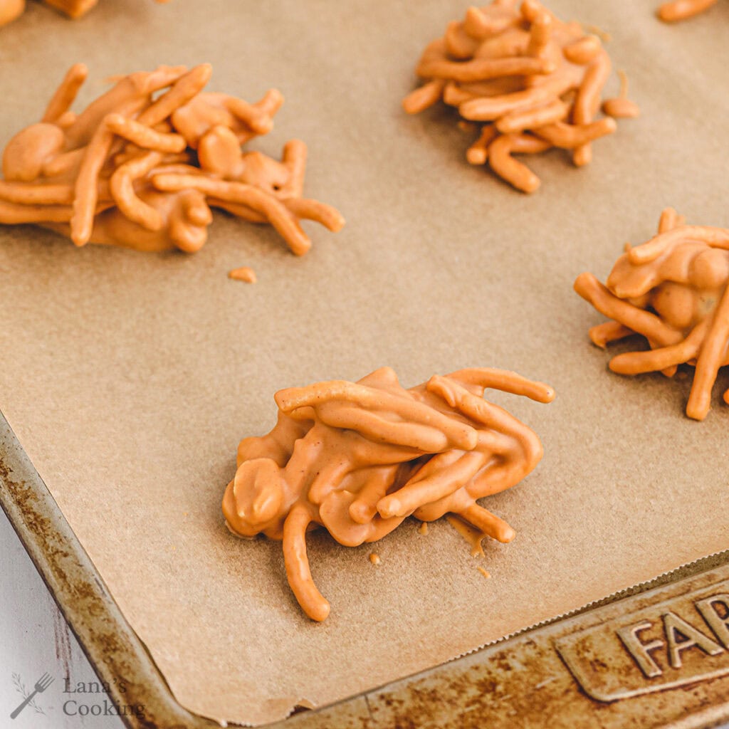 Clusters of Haystacks Candy on parchment paper atop a baking sheet.