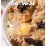 Close-up of apple pie oatmeal with raisins and pecans in a bowl, topped with a pat of melting butter.