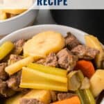 Bowl of Irish stew with beef, potatoes, carrots, and celery, with text Classic Irish Stew Recipe.