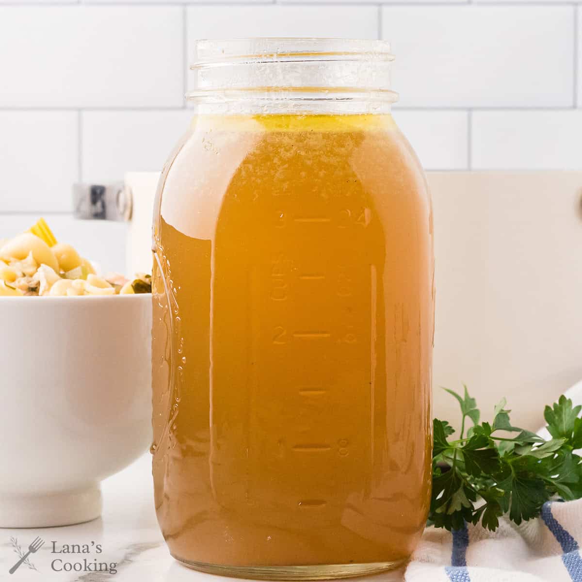 Finished chicken broth in a glass jar.