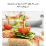 A BLT appetizer with bacon, lettuce, and tomato on bread, held together by a toothpick.