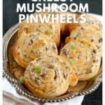 A silver platter with six cheesy mushroom pinwheels, garnished with green onions, on a white napkin.