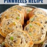 A platter of cheesy mushroom pinwheels with green onion garnish, labeled Cheesy Mushroom Pinwheels Recipe.