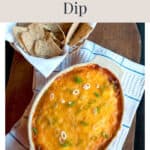 A baking dish of cheesy refried bean dip topped with green onions, served with a basket of tortilla chips.