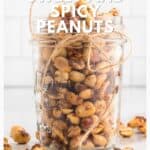 A glass jar filled with sweet and spicy peanuts, tied with twine, sits on a white surface.