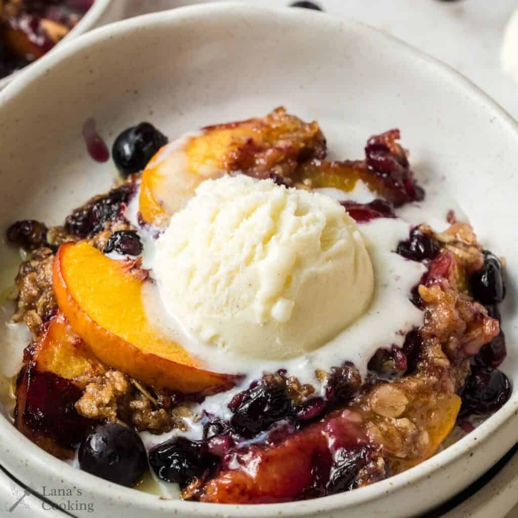 Blueberry Peach Crisp with ice cream on top.