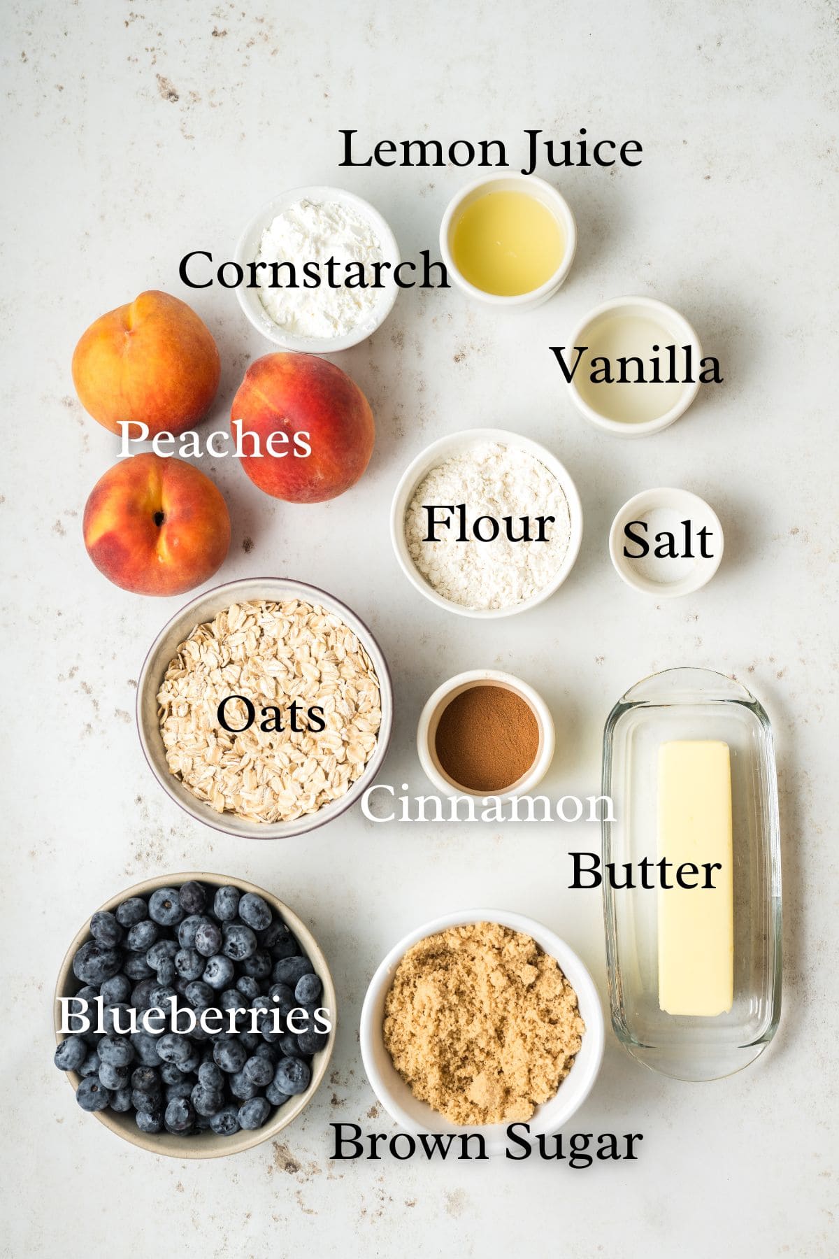 Ingredients for blueberry peach crisp on a white background.