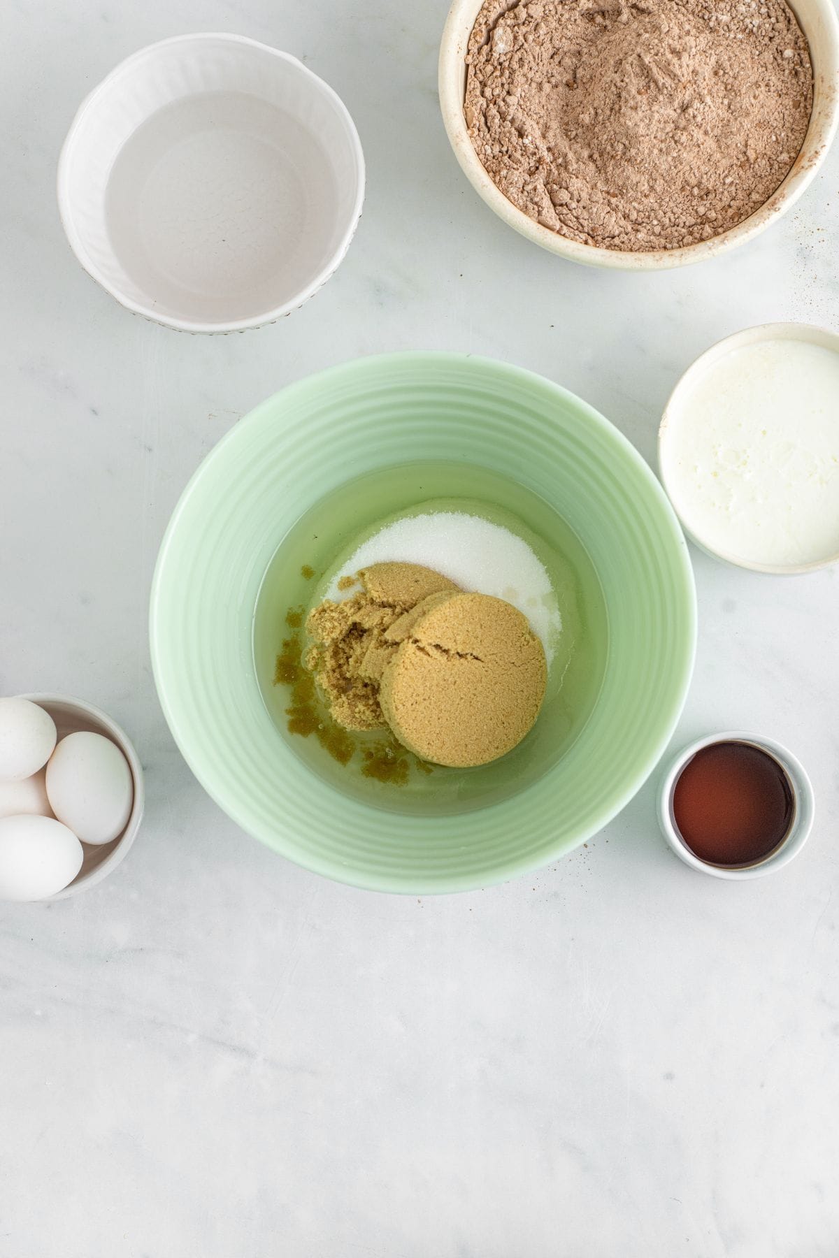 White and brown sugar and oil in a bowl.