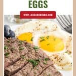 Sliced steak with sunny-side-up eggs and herbs on a white plate, garnished with blueberries.