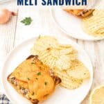 Oven baked tuna melt sandwich with potato chips on a white plate, garnished with parsley.