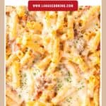 Close-up of cheesy baked ziti pasta with marinara sauce, melted cheese, and herbs on top.