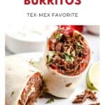 Two machaca burritos, one sliced open to show shredded beef, tomato, and herbs, on a white plate.