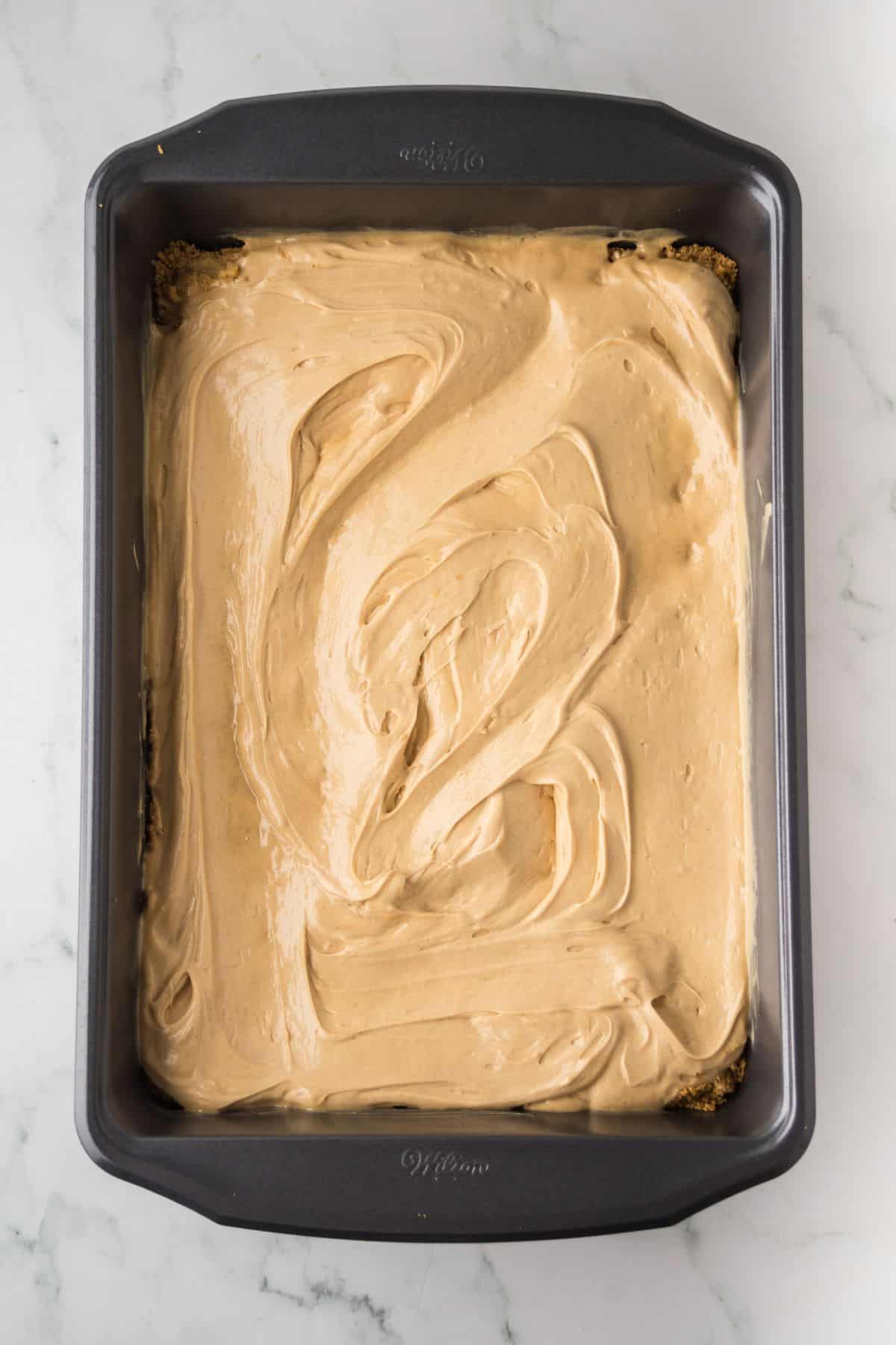 Peanut butter mixture spread over the graham cracker crust.