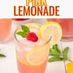 Pink lemonade in tall glasses with slices of lemon and strawberries.