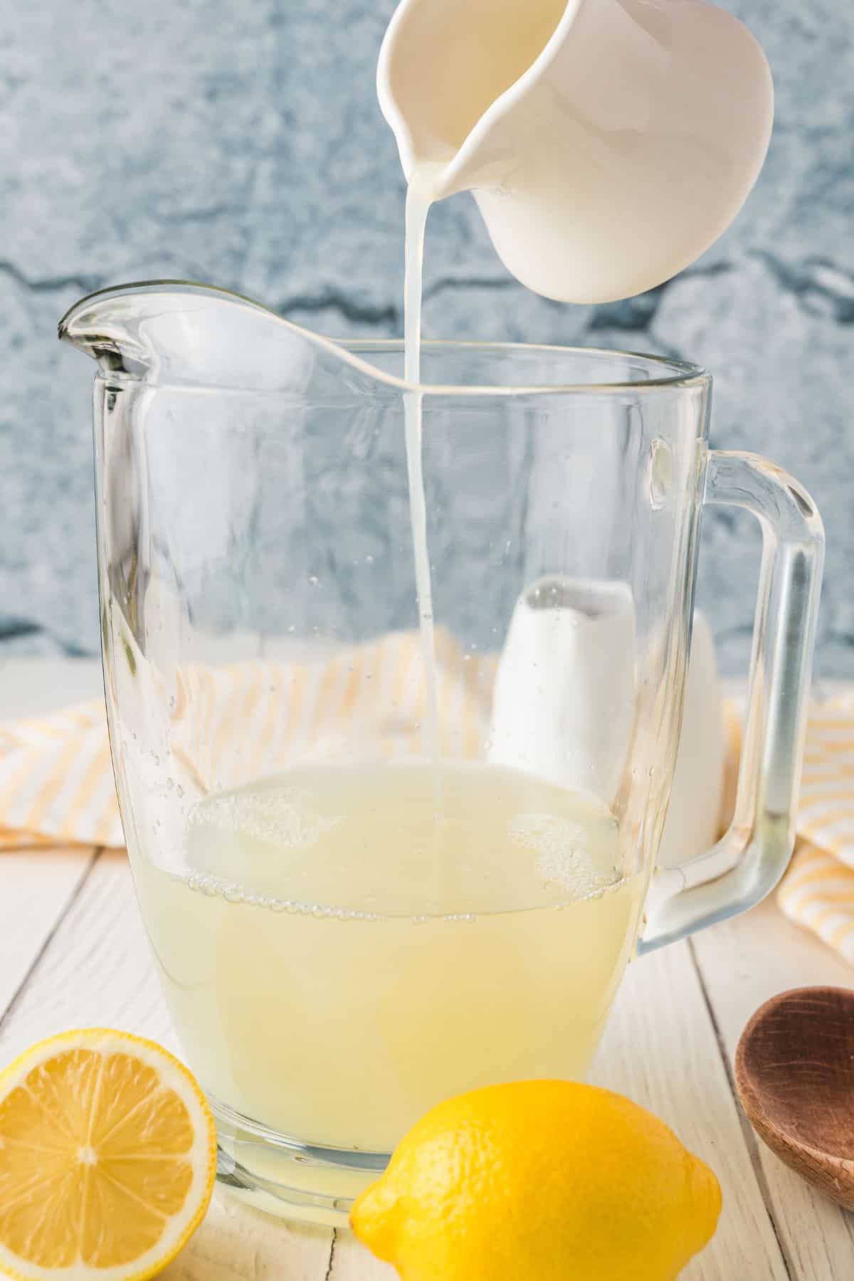 Adding lemon juice to the pitcher.