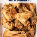 Platter of crispy fried chicken pieces garnished with chopped green onions, labeled Traditional Southern Fried Chicken.