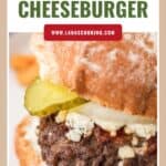 Close-up of a bacon cheeseburger with pickles, cheese, and a toasted bun.