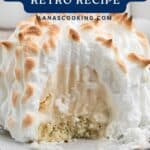 A slice of Baked Alaska dessert with toasted meringue, ice cream, and cake on a plate.
