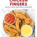 Plate of fried chicken fingers with red and yellow dipping sauces in bowls on a white background.