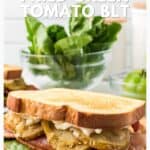 Two fried green tomato BLT sandwiches on toast with bacon, lettuce, and mayo, with fresh lettuce in the background.