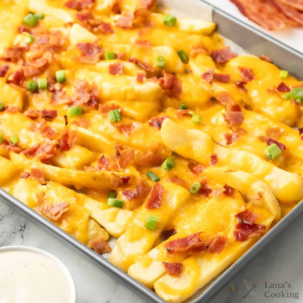 Finished loaded fries on a baking sheet.