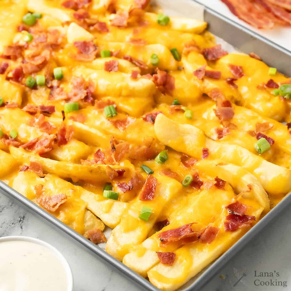 Finished loaded fries on a baking sheet.