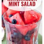Glass cup filled with watermelon cubes and blueberries, labeled Watermelon Mint Salad.