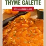 Apricot and thyme galette with golden crust, fresh thyme leaves, and apricot slices on top.
