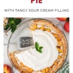 Fresh peach pie with sour cream filling, topped with whipped cream and mint, with one slice removed.