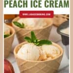 Scoops of peach ice cream in a waffle-style bowl, garnished with mint, with peach and towel nearby.