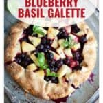 A pineapple, blueberry, and basil galette on a baking sheet with a website link at the bottom.