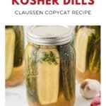 A jar of homemade kosher dill pickles with fresh dill, garlic, and cucumbers next to a recipe label.