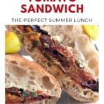 Close-up of a roasted tomato sandwich with fresh bread, veggies, and creamy filling, advertised as a summer lunch.