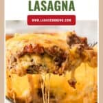 A cheesy slice of egg noodle lasagna being lifted from a pan, with melted cheese stretching.