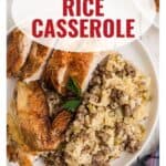 Plate with sliced roasted chicken and sausage rice casserole, garnished with parsley.