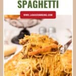 A fork lifts cheesy baked spaghetti from a casserole dish, with a golden melted cheese topping.