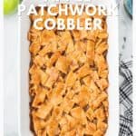 A baked apple cobbler with a patchwork crust in a white dish on a marble surface, with apples nearby.