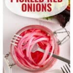 A jar of pickled red onions with a fork beside a sign that says Pickled Red Onions.