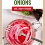 Jar of pickled red onions with forks, leafy greens, and a website link at the top reading lanascooking.com.