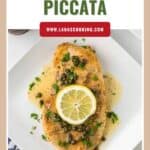 A plate of chicken piccata topped with capers, sauce, fresh herbs, and a lemon slice on a white square plate.