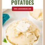 A bowl of mashed potatoes topped with a pat of butter and sprinkled with herbs.