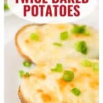 Two twice baked potatoes topped with melted cheese and chopped green onions on a white plate.