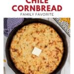 Cheesy green chile cornbread in a cast iron skillet with a pat of butter on top, text above and below.