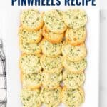 A platter of golden, cheesy spinach pinwheels arranged neatly on a white rectangular plate.