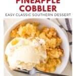 Bowl of southern pineapple cobbler topped with vanilla ice cream, with a spoon and striped napkin beside it.