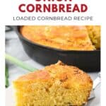 A slice of sour cream and onion cornbread sits on a plate, with the rest in a cast iron skillet nearby.